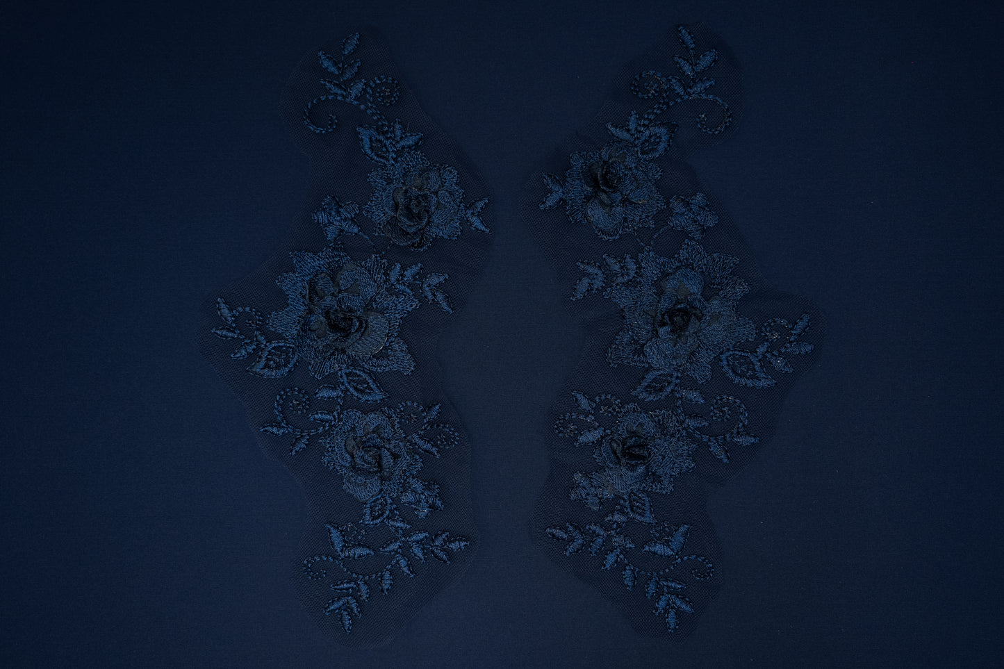 Pair of decorative earrings on a dark blue background