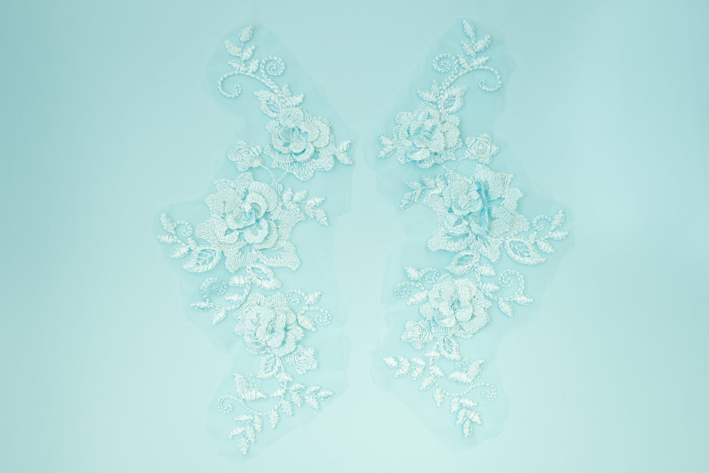 Decorative white floral pattern on a light blue background