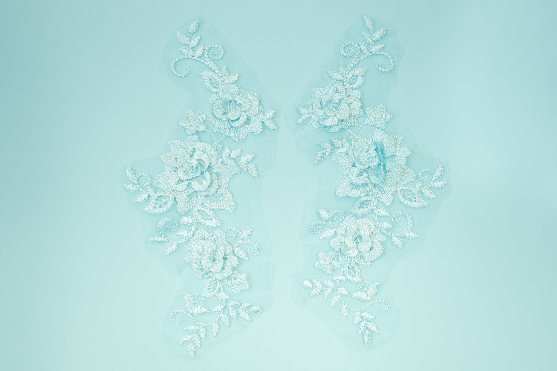 Decorative white floral pattern on a light blue background