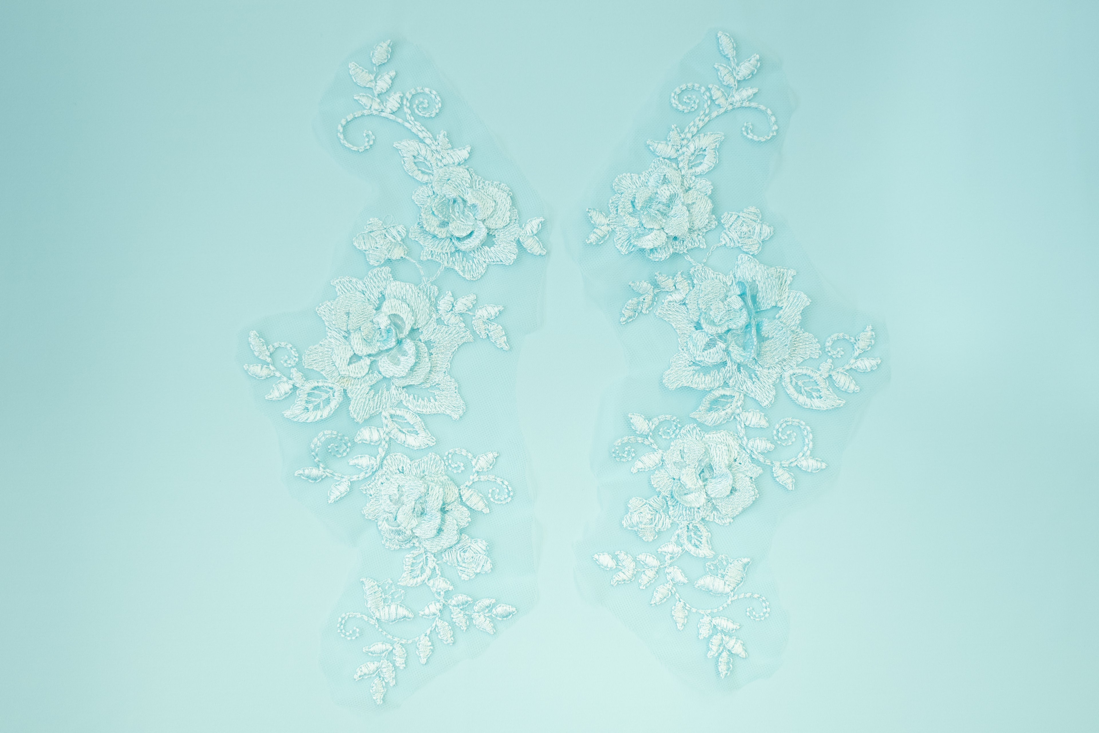 Decorative white floral pattern on a light blue background