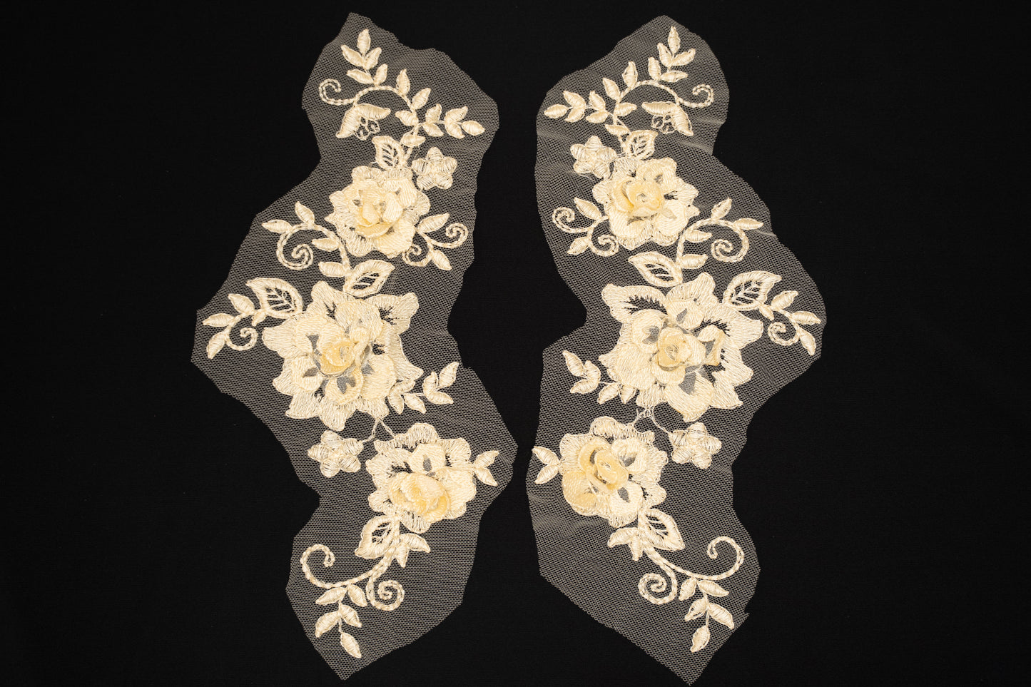 Pair of floral lace appliqués on a black background