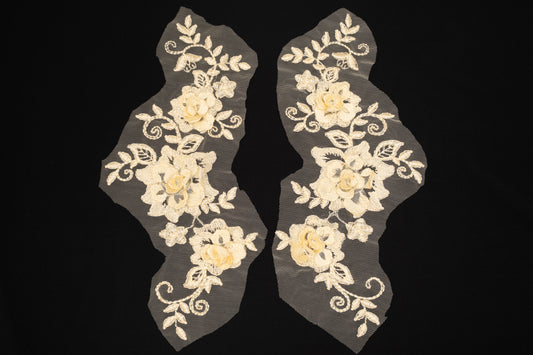 Pair of floral lace appliqués on a black background