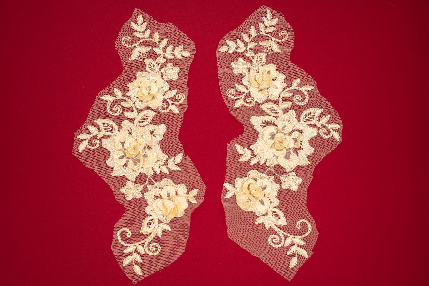 Pair of floral lace appliqués on a red background