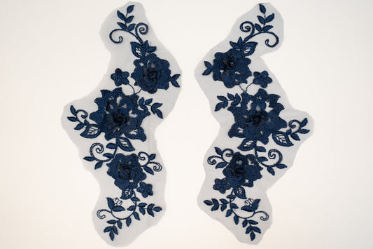 Pair of blue floral lace patches on a white background
