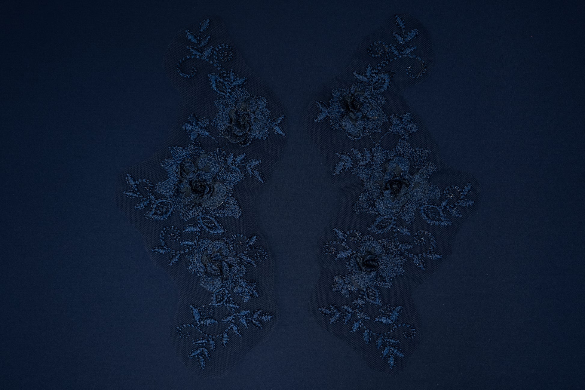 Pair of decorative earrings on a dark blue background