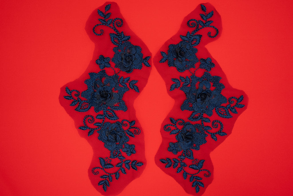 Pair of black floral lace patches on a red background