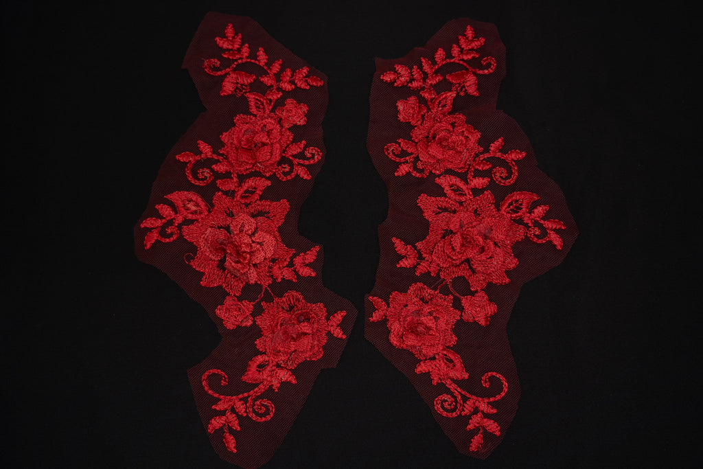 Red floral lace patches on a black background