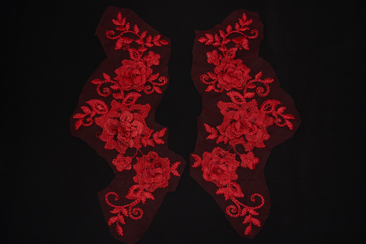Red floral lace patches on a black background