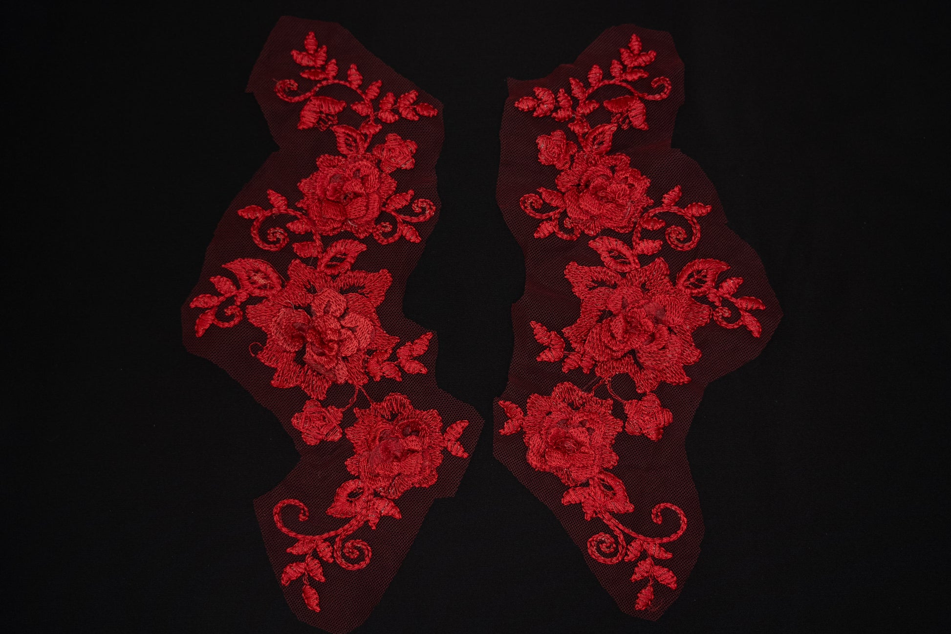 Red floral lace patches on a black background