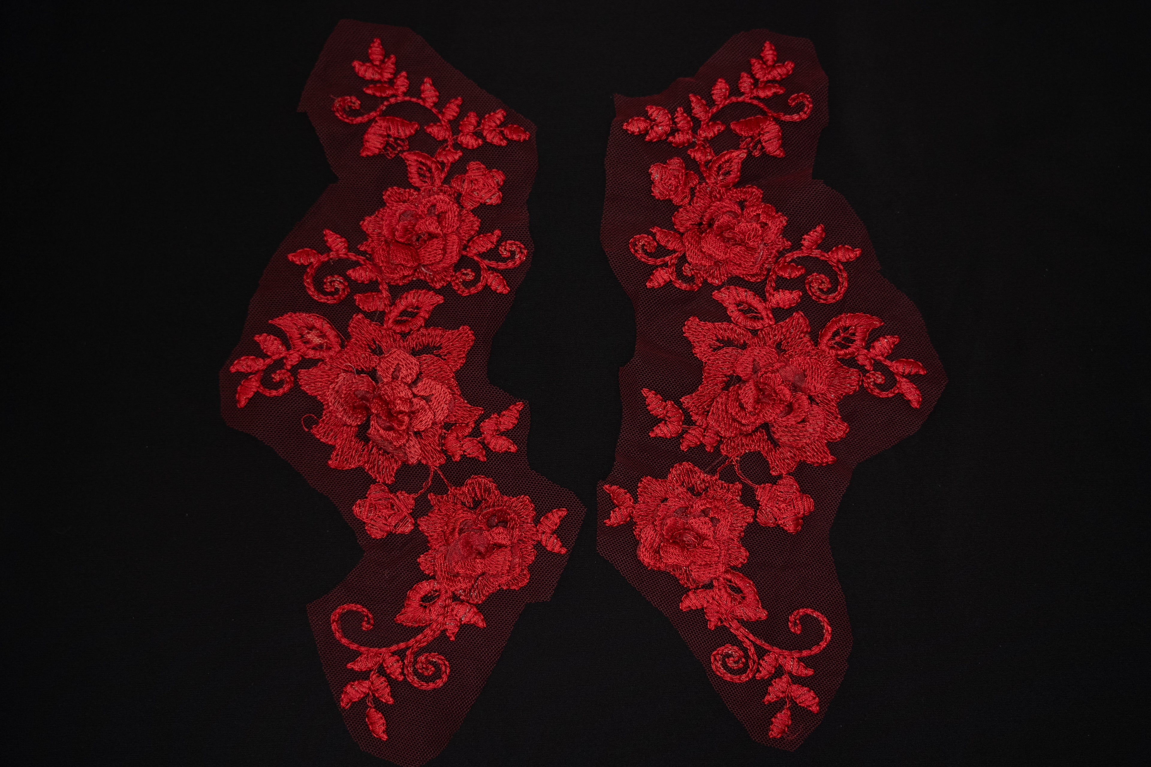Red floral lace patches on a black background