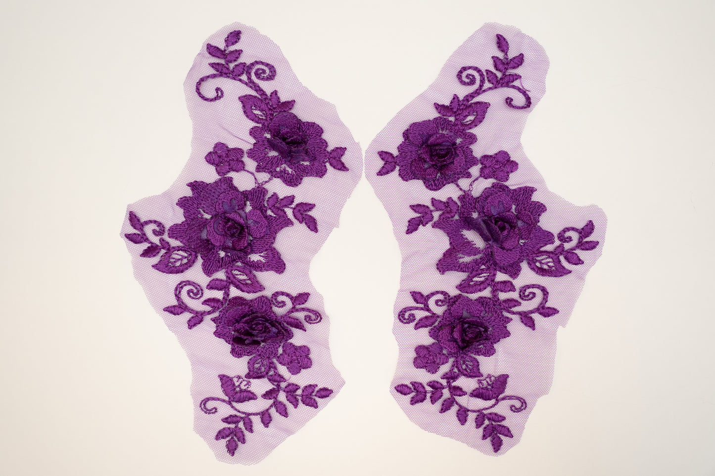 Pair of purple floral lace socks on a white background