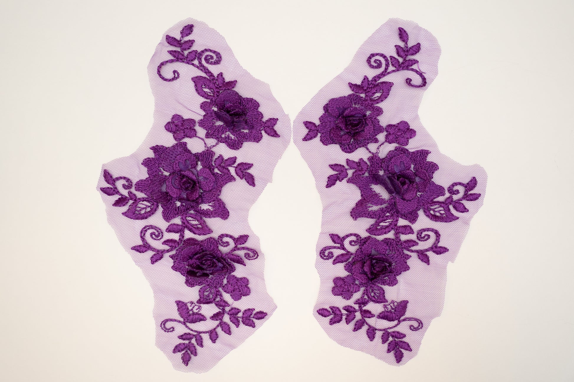 Pair of purple floral lace socks on a white background