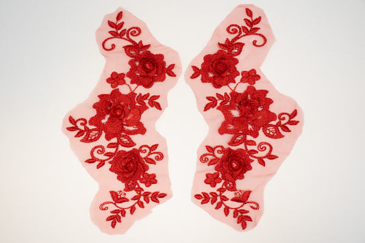 Two red floral lace appliqués on a white background
