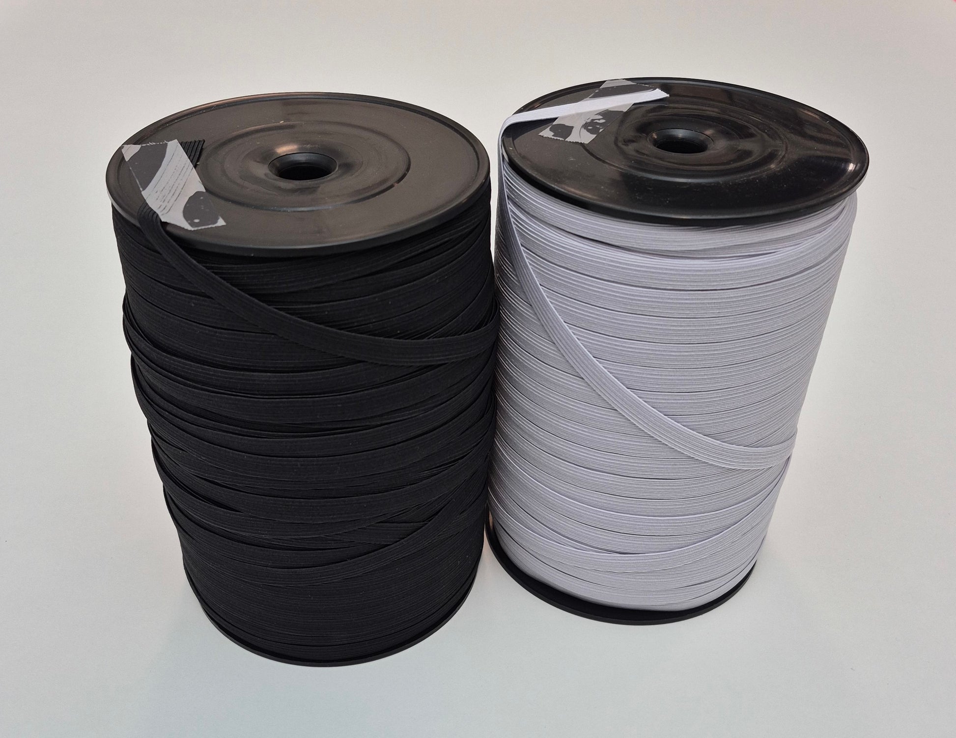 Two spools of ribbon, one black and one white, on a light gray background.