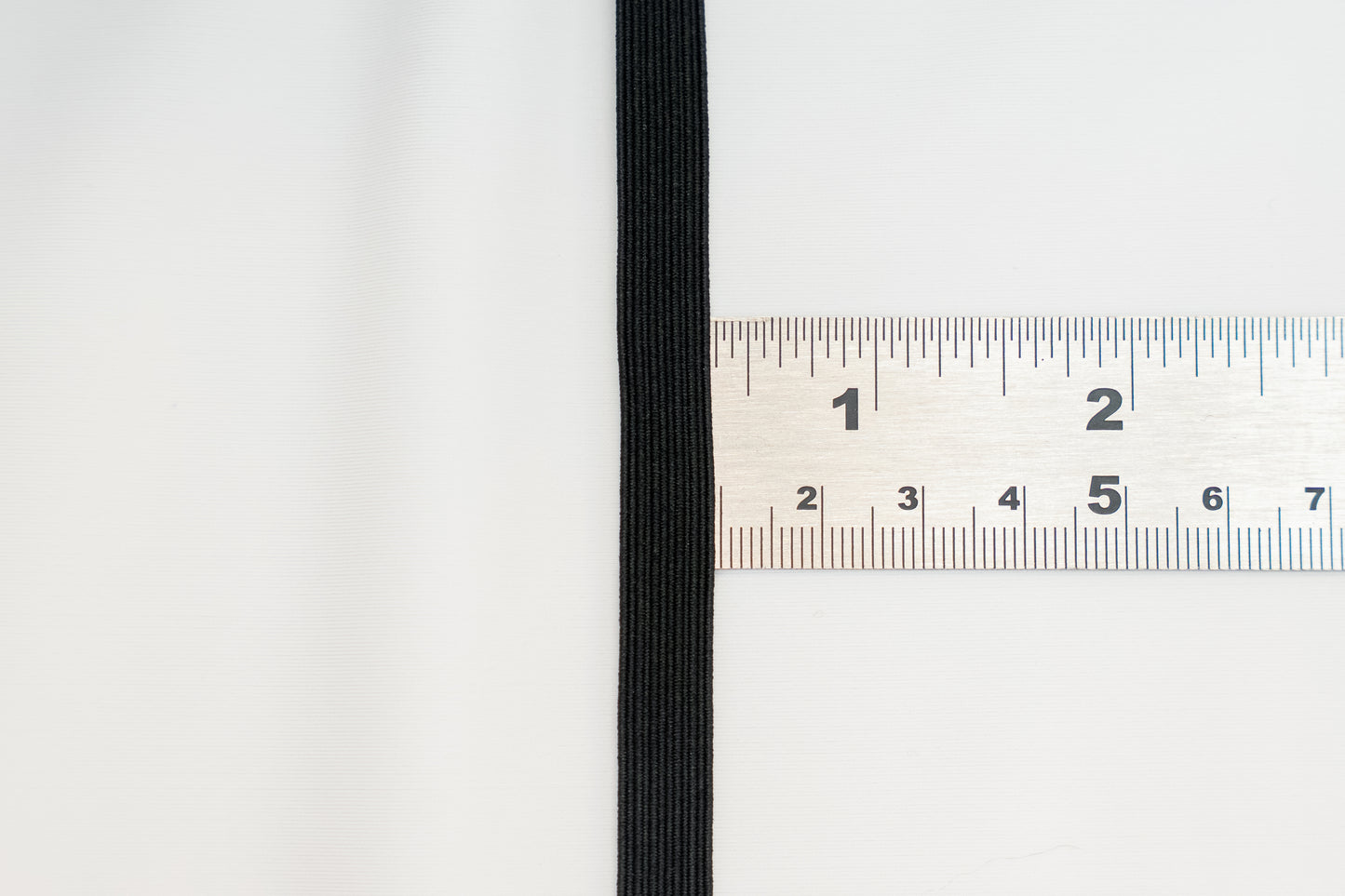 black flat braided elastic on a ruler