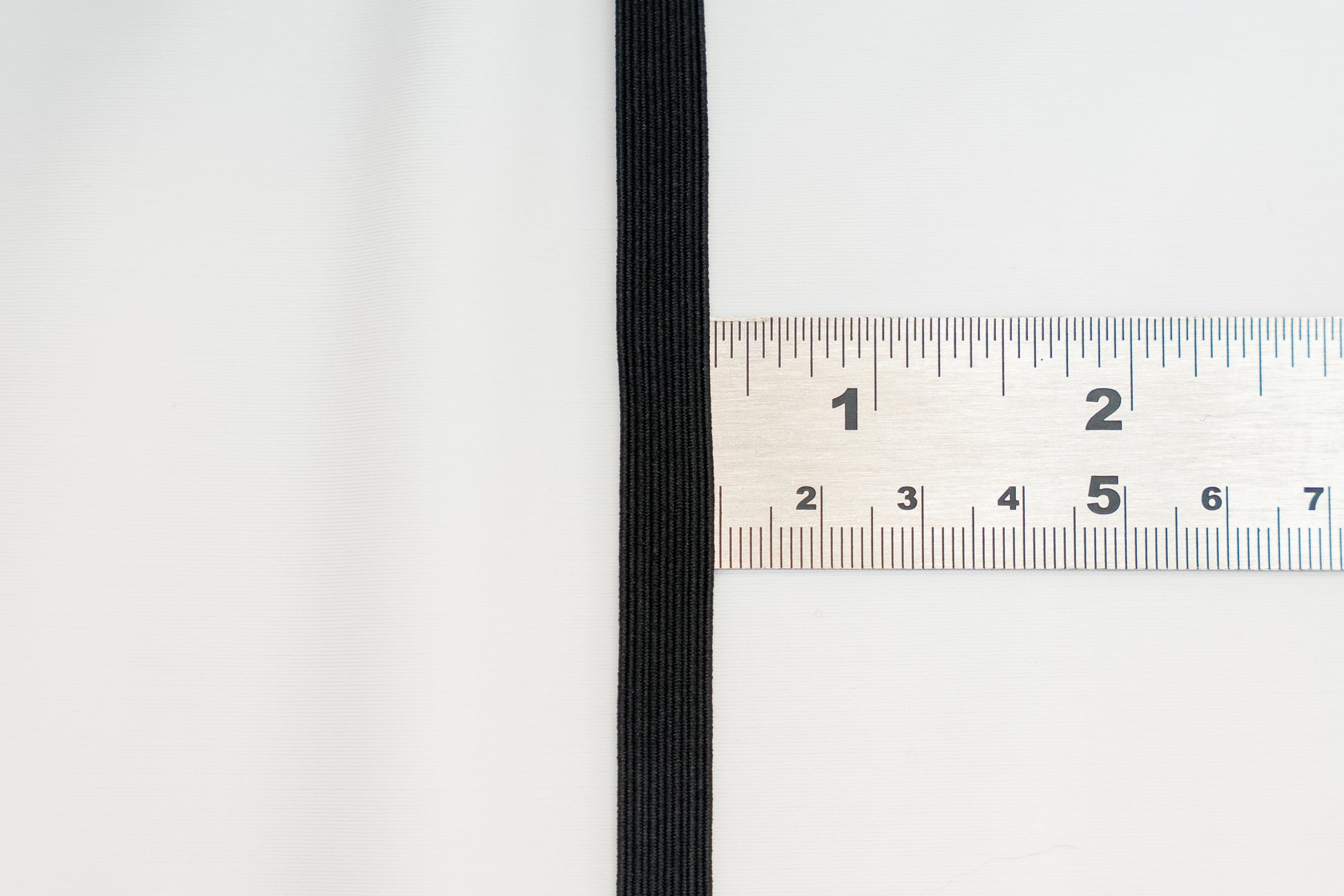 black flat braided elastic on a ruler