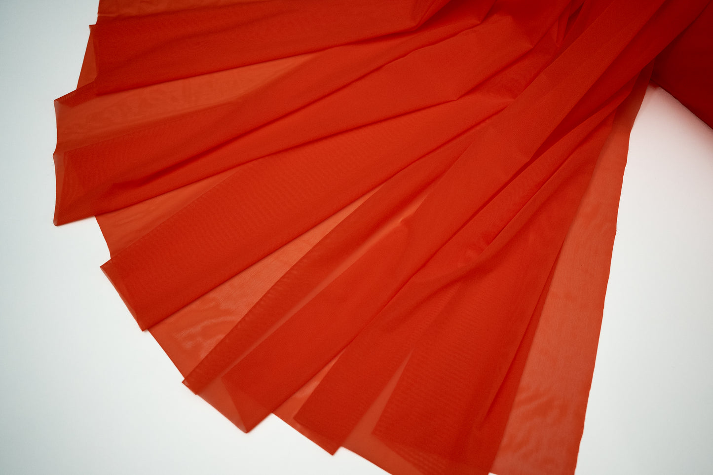 Red fabric with pleated design on a white background