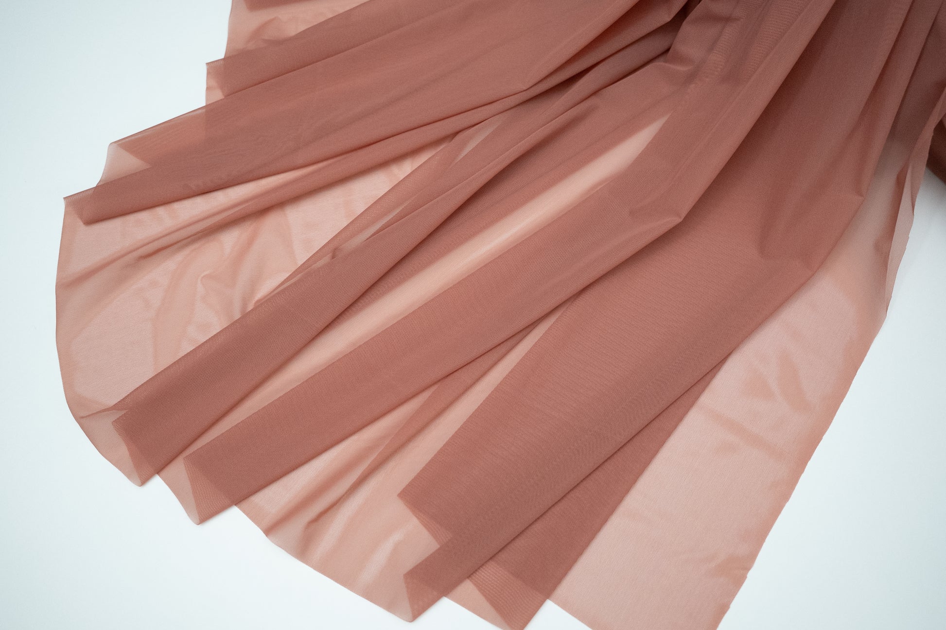 Pink fabric with pleated texture on a white background
