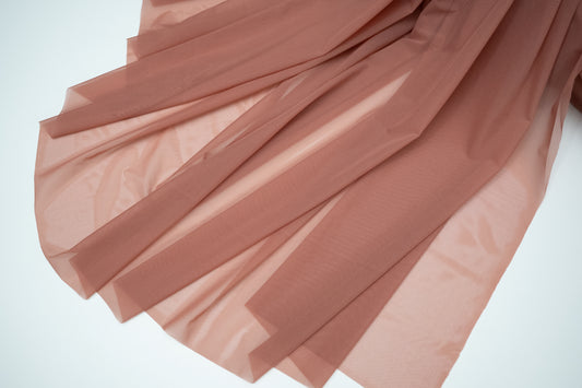 Pink fabric with pleated texture on a white background