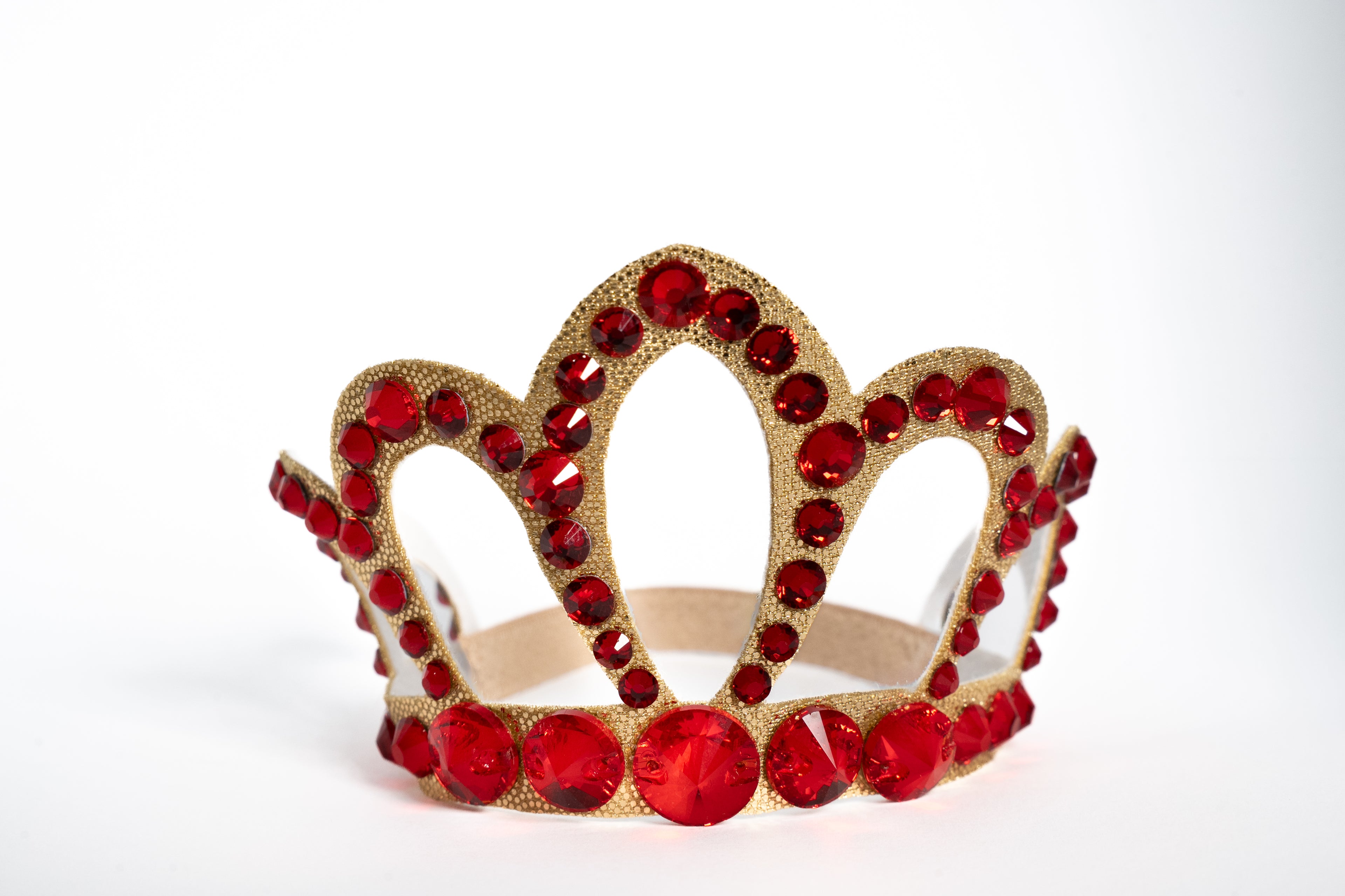 Gold crown with red gemstones on a white background