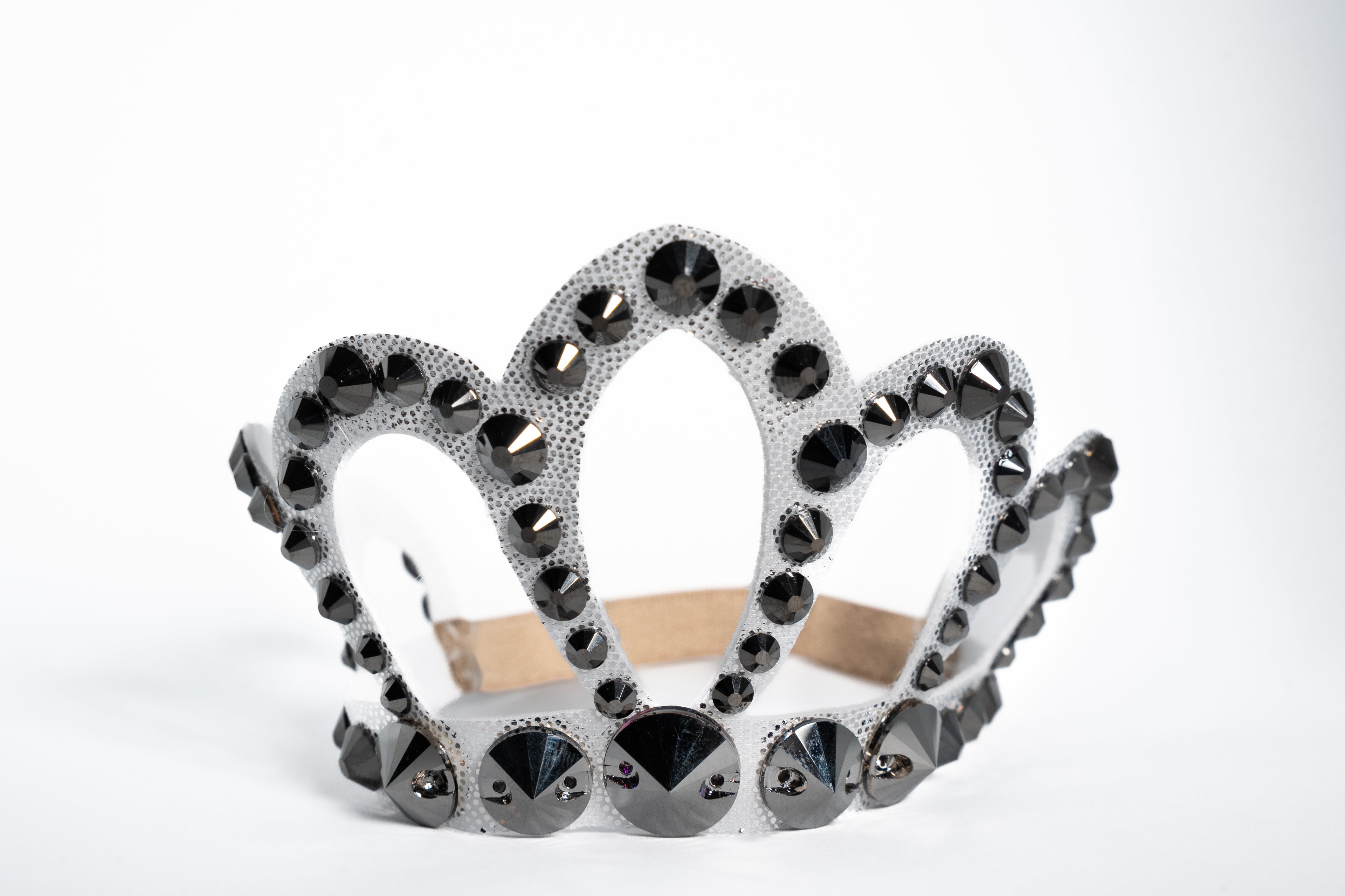 Decorative crown with black gemstones on a white background