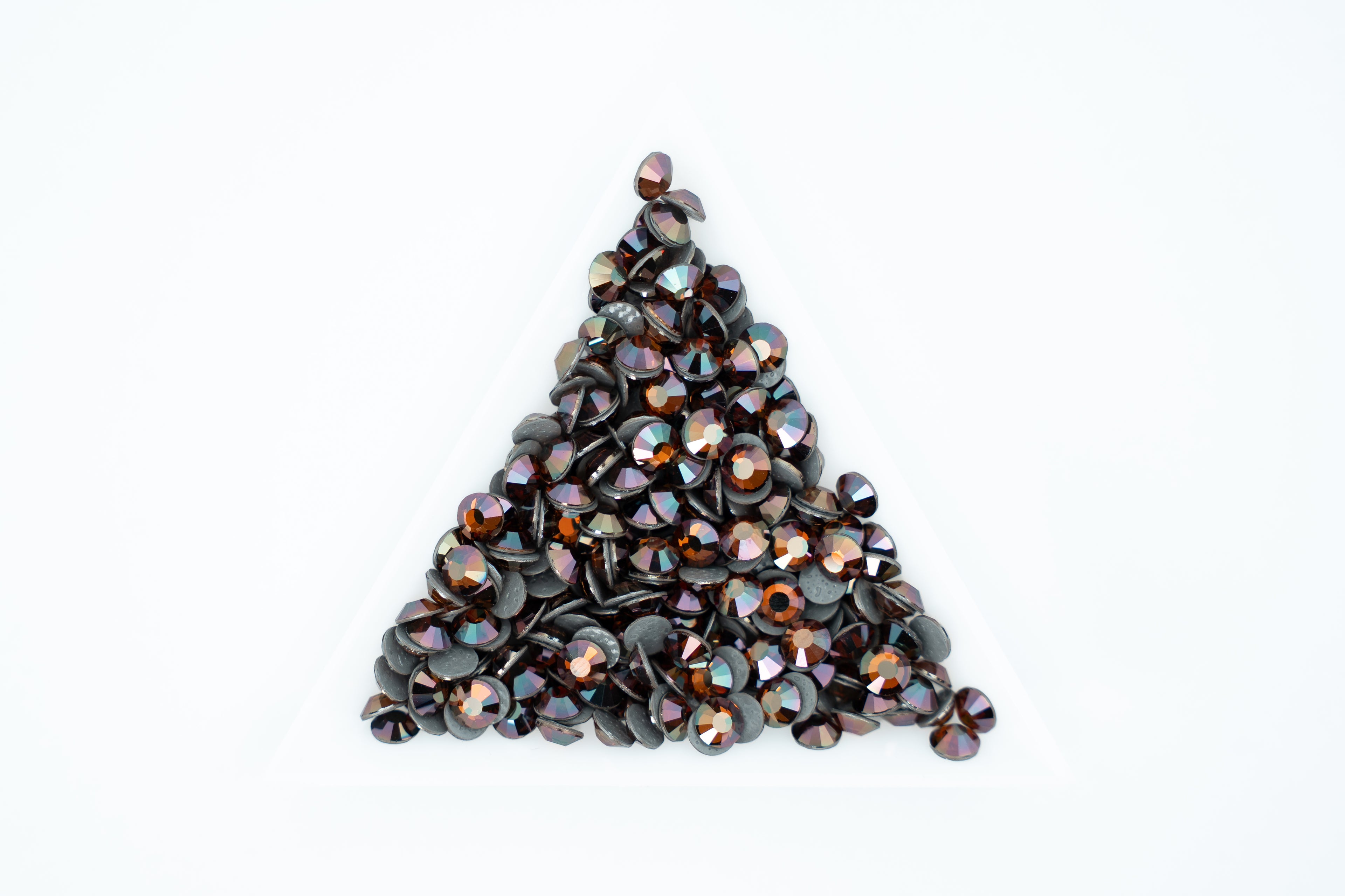 A pile of small round iridescent gemstones or rhinestones arranged in a triangle on a plain white background.